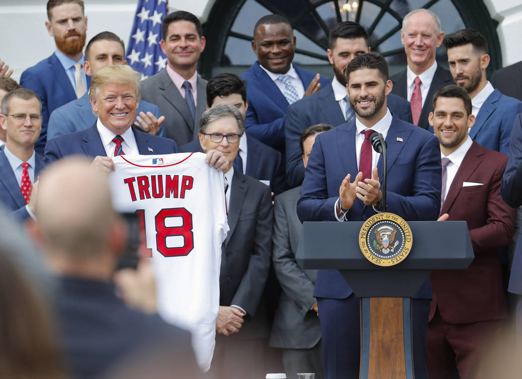 President Donald Trump, left, holds up a team jersey that was presented to him by outfielder J. ...