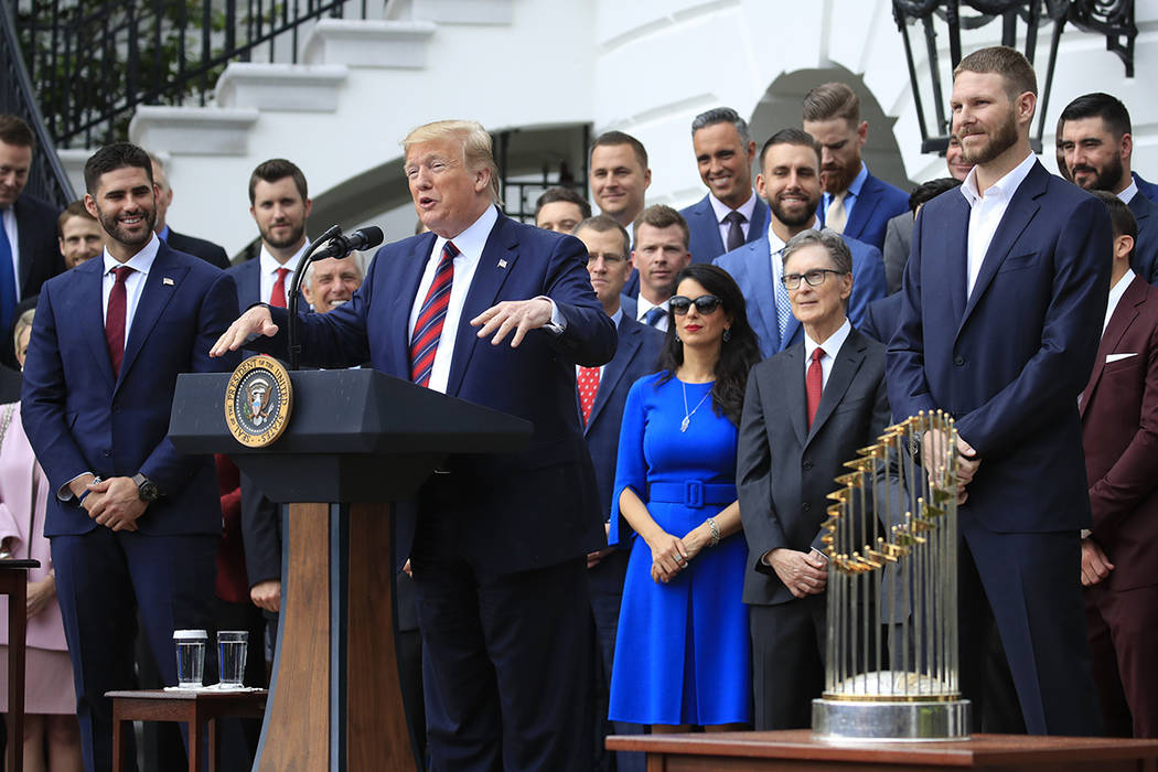 President Donald Trump flanked by Red Sox players Chris Sale, right, and J. D. Martinez, left, ...