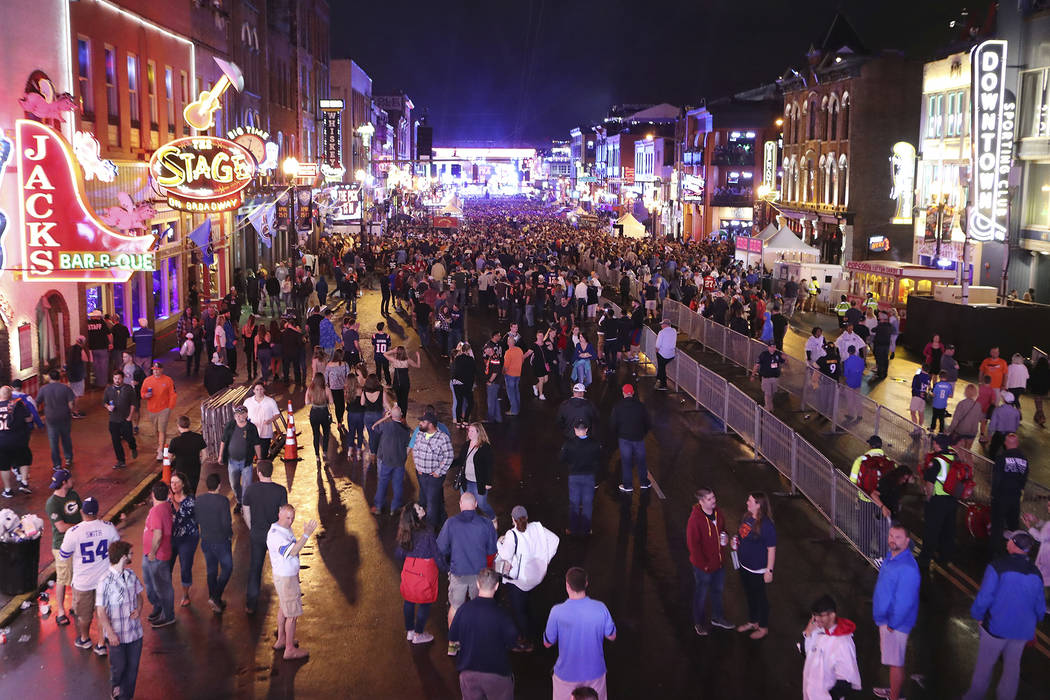 Fans line up Broadway in the rain to watch the first round of the NFL football draft in Nashvil ...