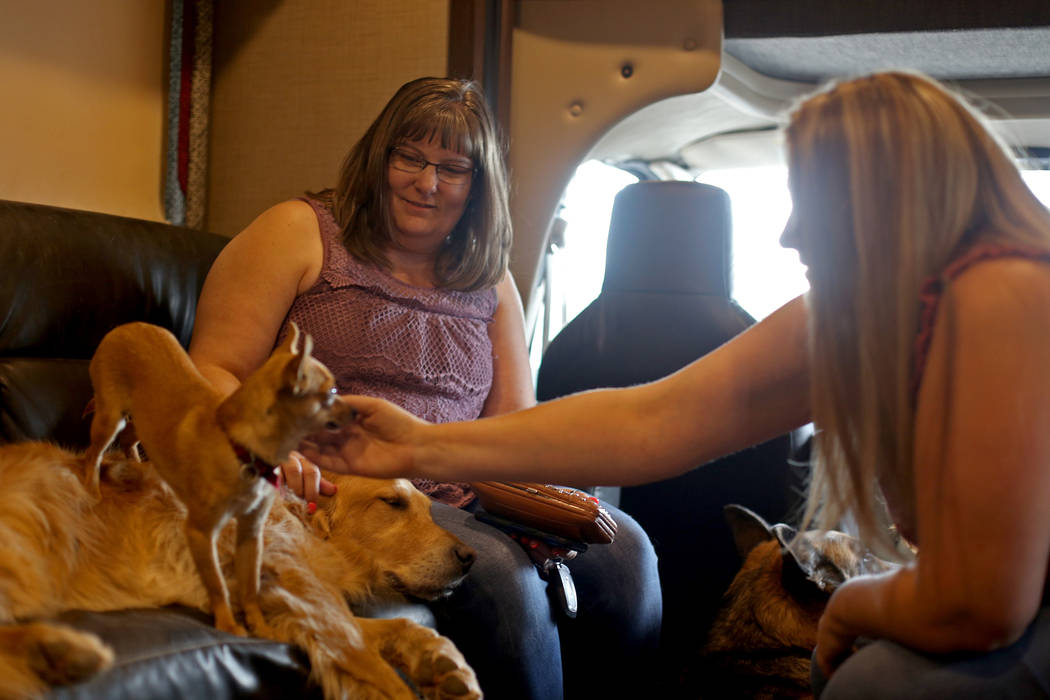 Trisha Roe, from left, and Renne Babiracki, both of Oregon, pet Penny and Cali in The Asher Hou ...