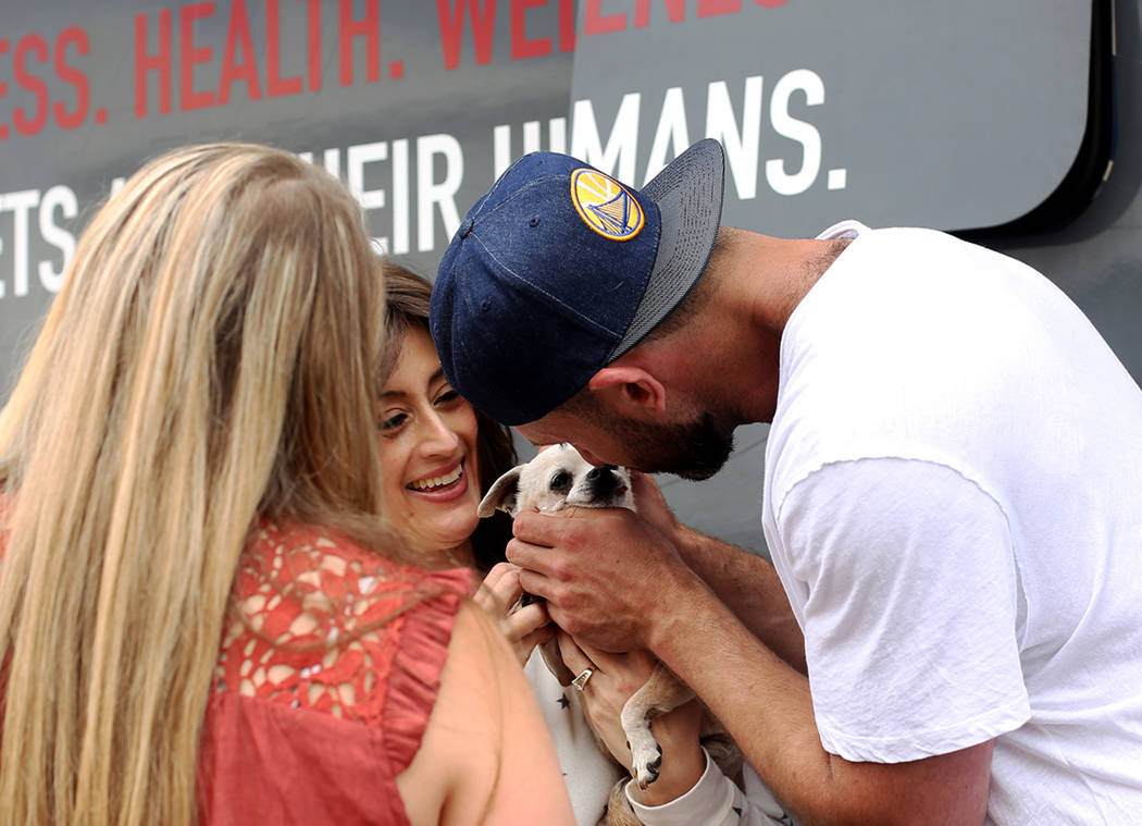 Paula Ditusa holds Queen as Lee Asher pets her outside The Asher House RV in the parking lot of ...