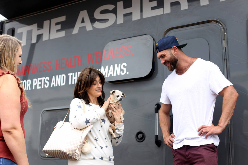 Paula Ditusa holds Queen as Lee Asher talks to Renne Babiracki outside The Asher House RV in th ...