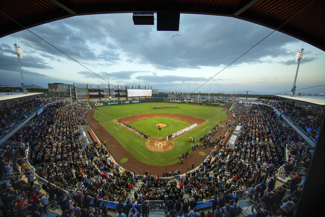 Four F-16 jets from Nellis Air Force Base fly over the ballpark with an American flag unfurled ...