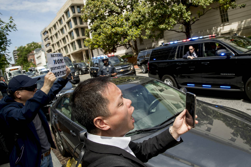 Protesters shout as the motorcade carrying Chinese Vice Premier Liu He and his delegation depar ...