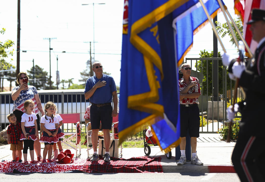 Attendees stand as members of the Las Vegas firefighters pipe & drum band perform during th ...