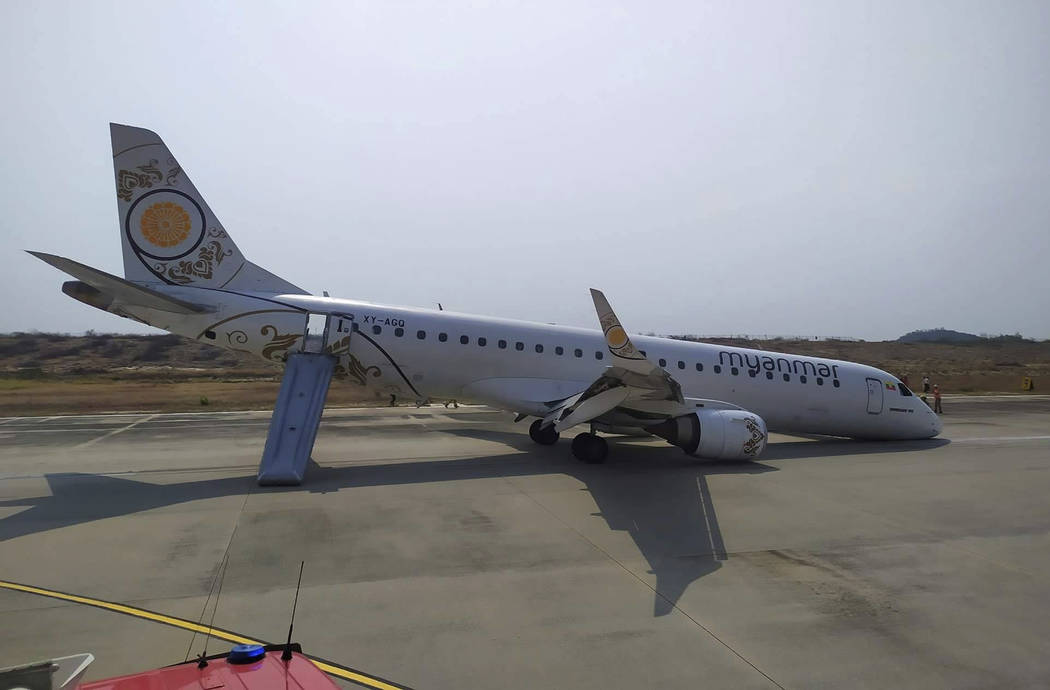 Rescue team gather near a plane of Myanmar National Airline (MNA) after an accident at Mandalay ...