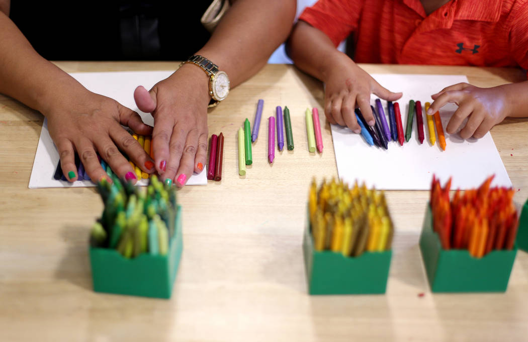 Maria Tawresey works on crayon art that will be melted with her son Zachary Tawresey, 5, at the ...