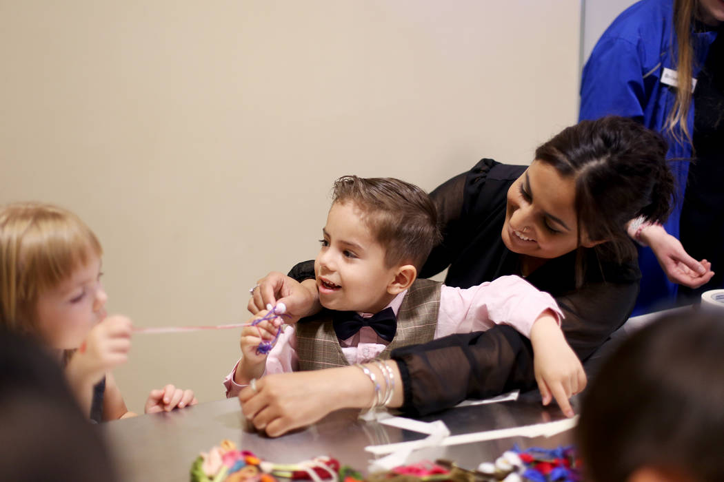 Noah Vidmar, 4, works on a friendship bracelet with his mom Natasha Vidmar and friend Penny Jon ...