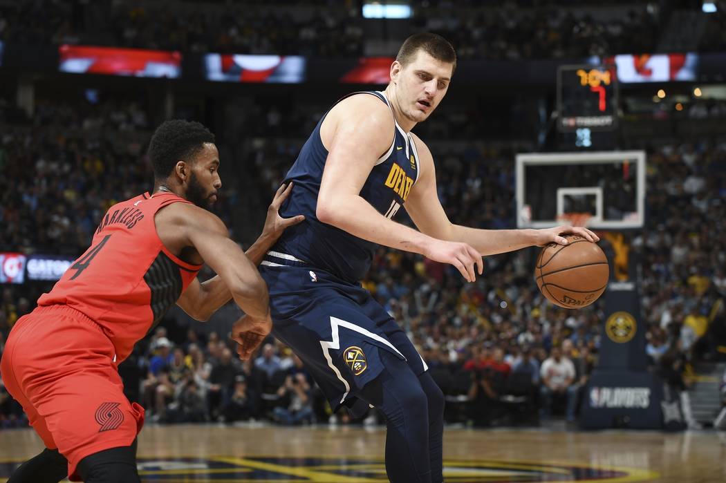 Denver Nuggets center Nikola Jokic, right, works the ball inside to the rim as Portland Trail B ...