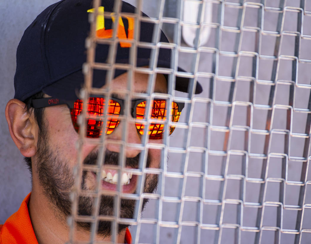 The Aviators assistant groundskeeper Andres Portillo is ready with a grate to work the infield ...