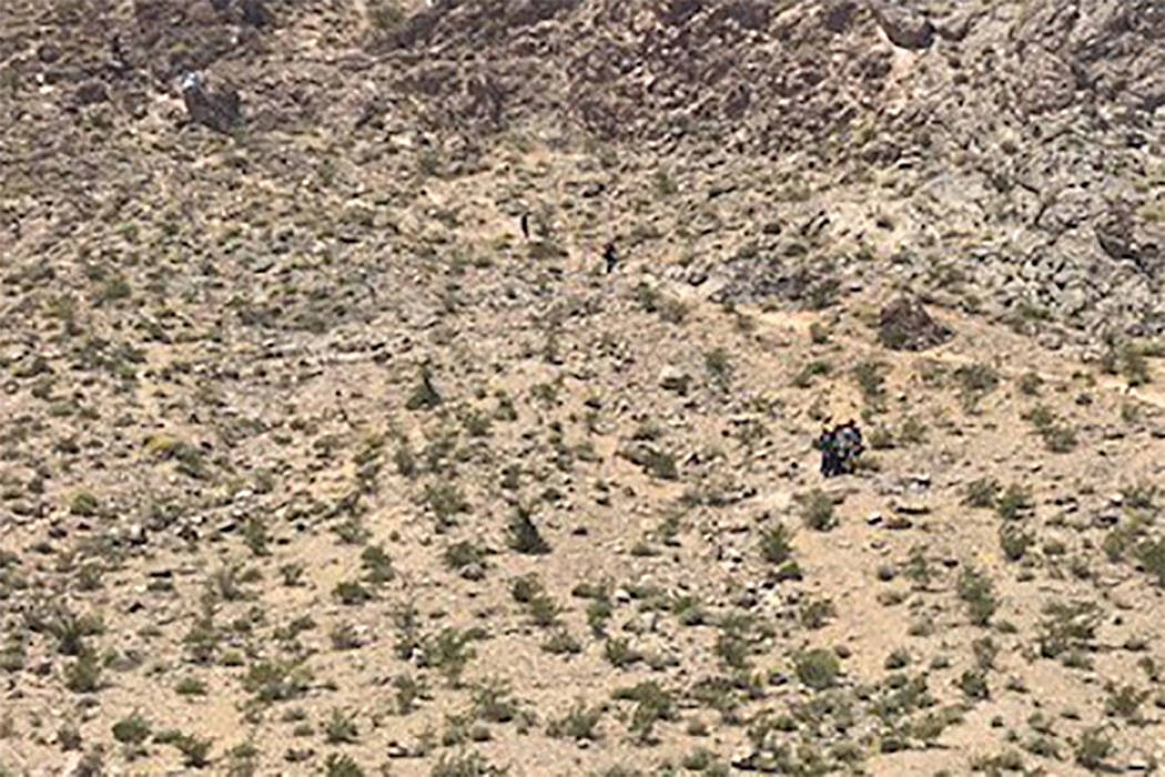 Rescuers carry a sick hiker down Lone Mountain in Las Vegas on Sunday, May 12, 2019. (Las Vegas ...