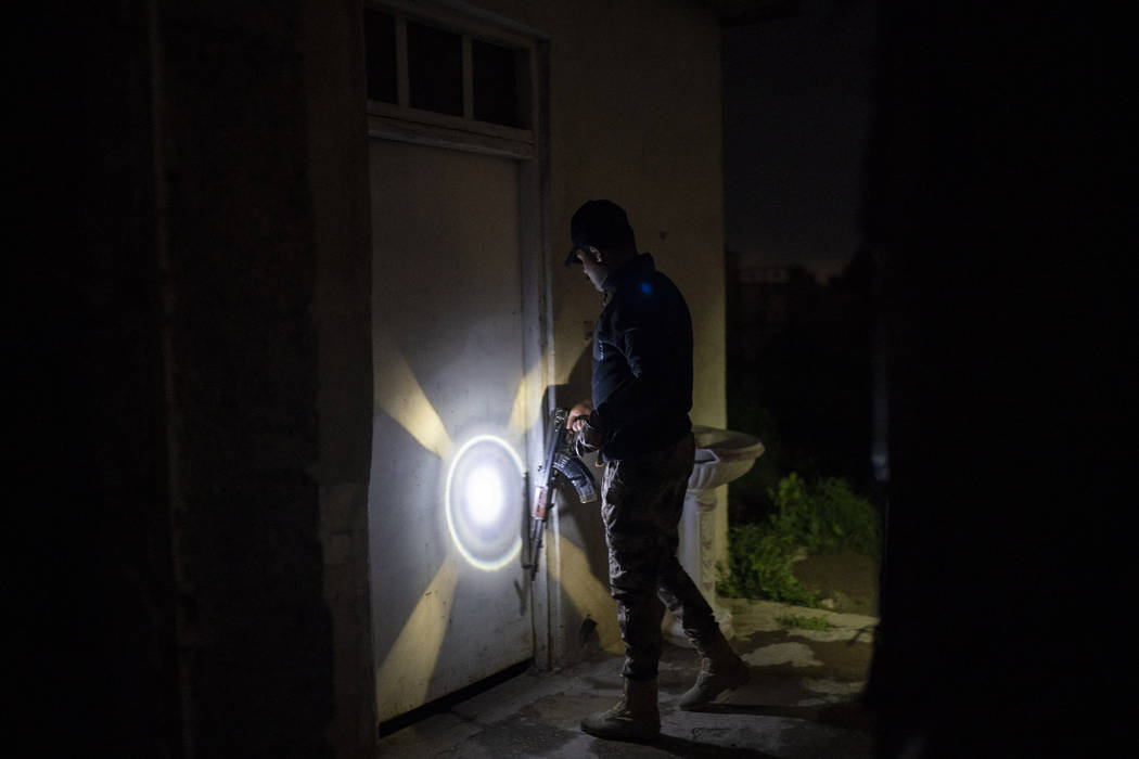 In this April 2, 2019 photo, an Iraqi army 20th division soldier uses his AK-47 rifle to knock ...