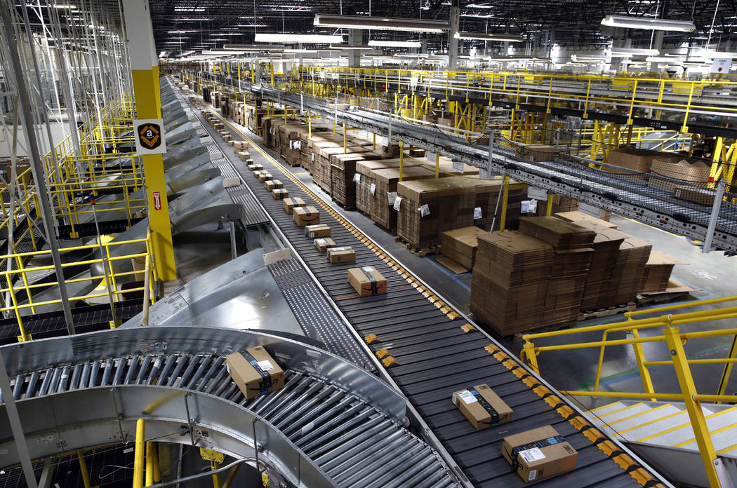 In this Aug. 3, 2017, file photo, packages ride on a conveyor system at an Amazon fulfillment c ...