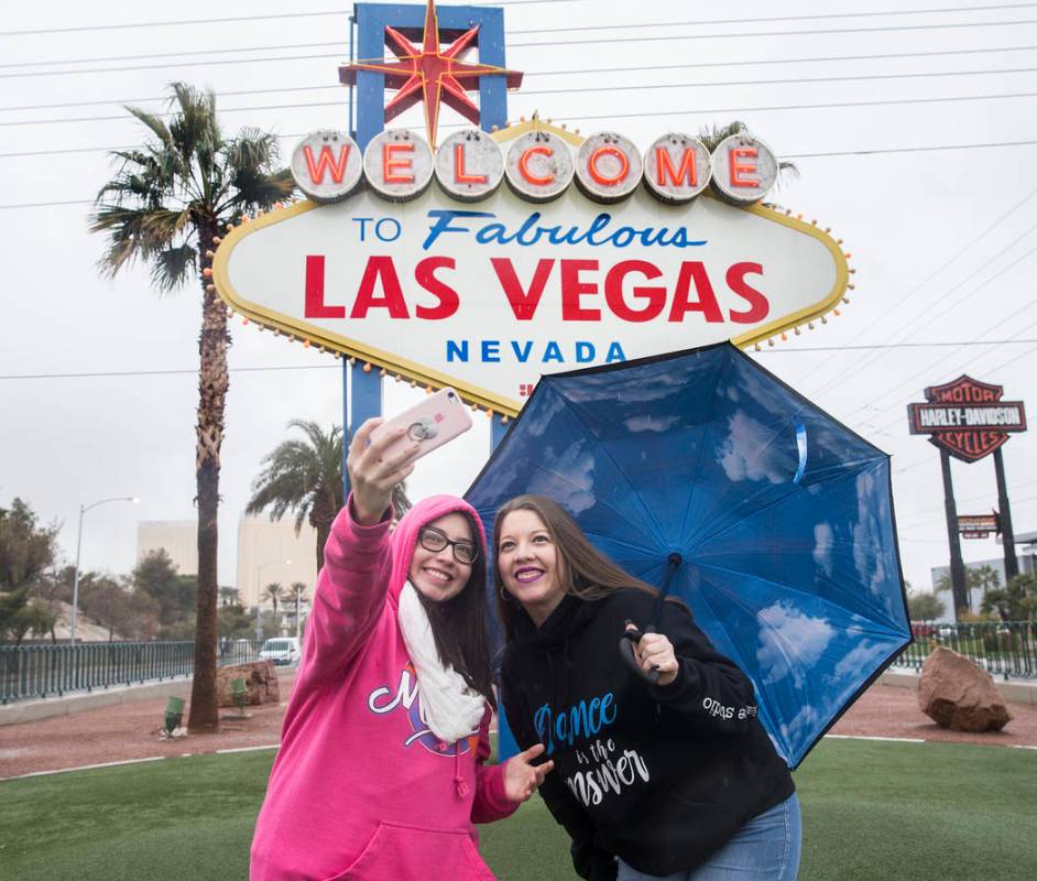 Heavy rain doesn't stop Estefania Vazquez, left, and Valeria Vazquez, from Escondido, Calif., f ...