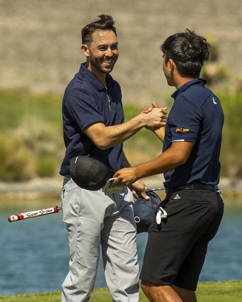 Golfers Brett Kanda and Alexander Kang celebrate their qualifying score on the 18th hole during ...