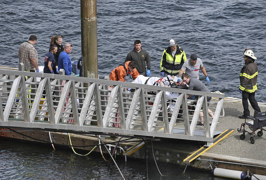 Emergency response crews transport an injured passenger to an ambulance at the George Inlet Lod ...