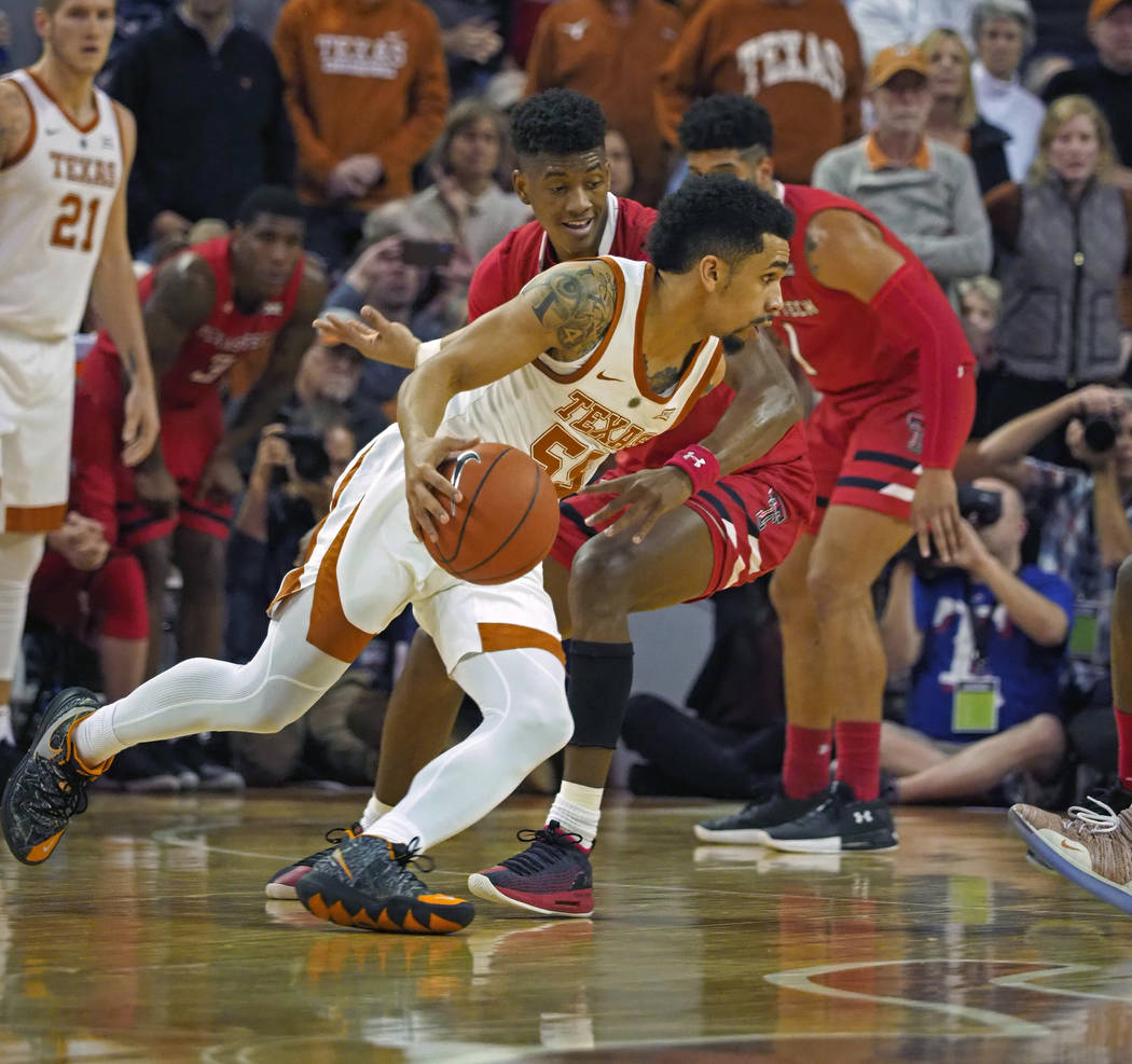 Texas guard Elijah Mitrou-Long, front, drives the ball against Texas Tech guard Jarrett Culver ...