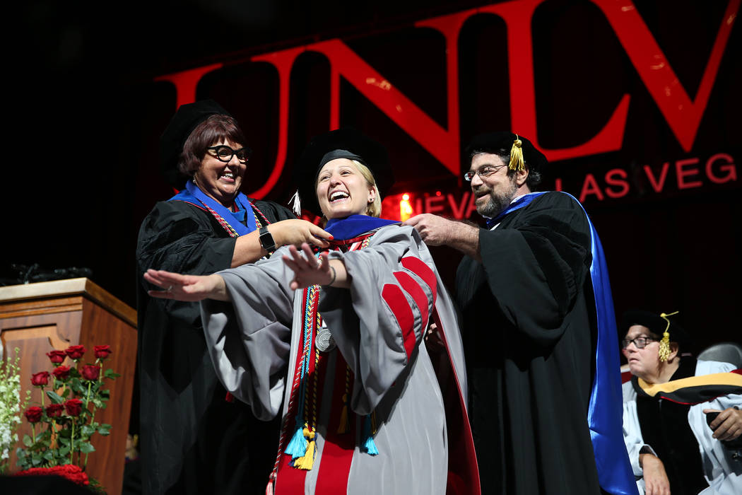 Sociology doctorate graduate Valarie Burke is hooded by Kate Korgan, left, dean of the graduate ...