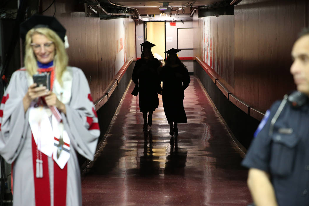 Graduates attend the UNLV commencement ceremony at the Thomas & Mack Center in Las Vegas, S ...