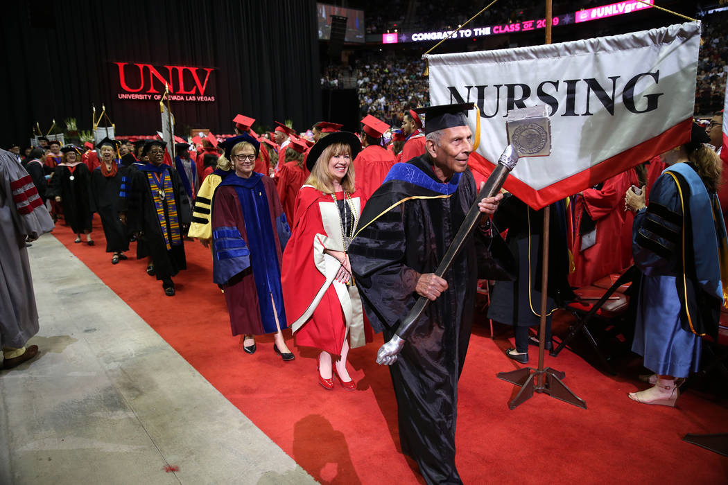 Grand marshal Sadanand Verma, right, followed by UNLV president Marta Meana, lead the platform ...