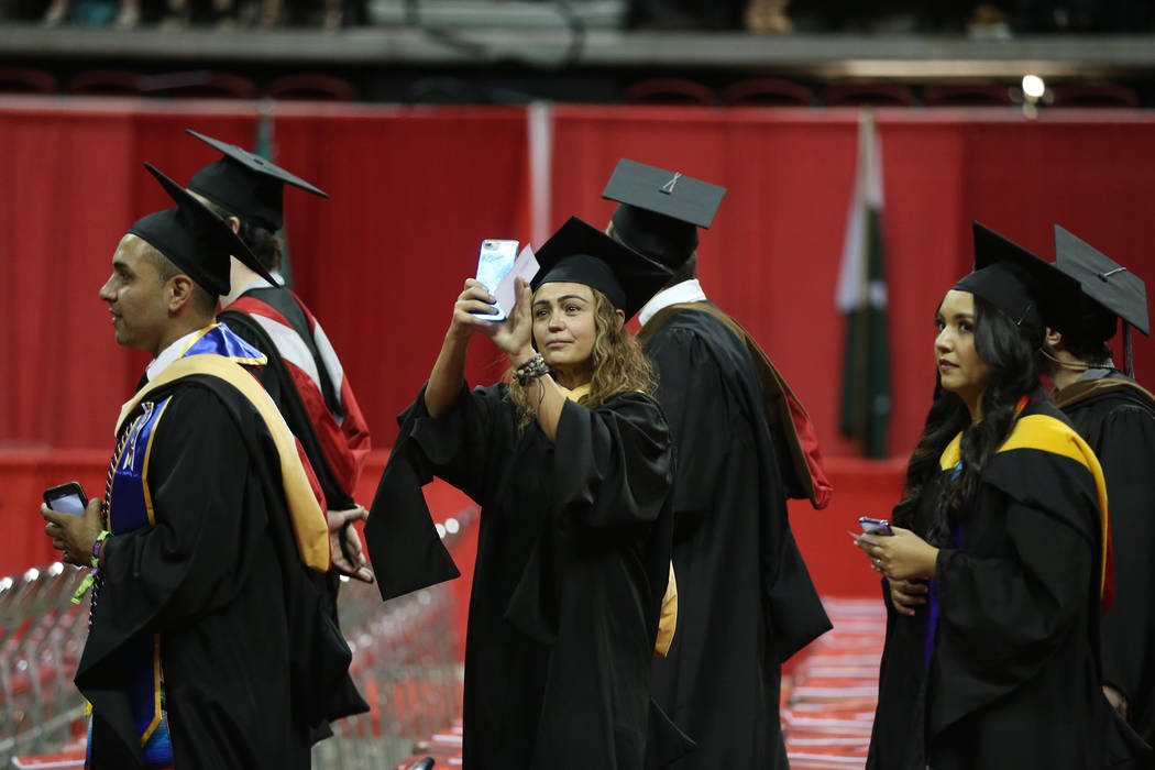 Graduates attend the UNLV commencement ceremony at the Thomas & Mack Center in Las Vegas, S ...