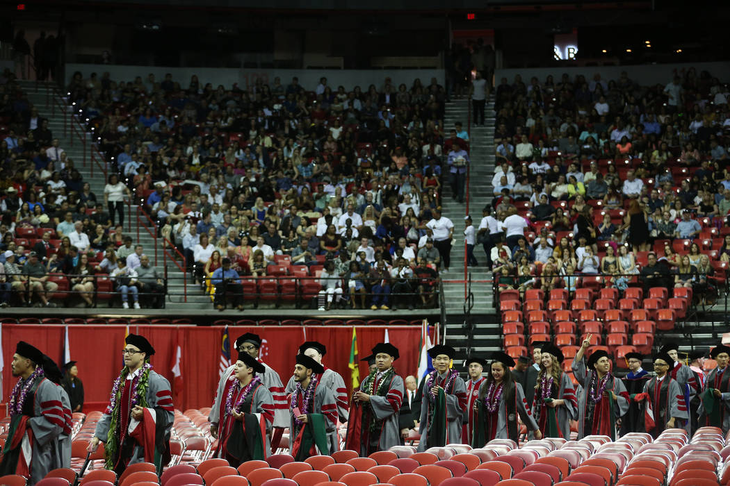 Graduates attend the UNLV commencement ceremony at the Thomas & Mack Center in Las Vegas, S ...