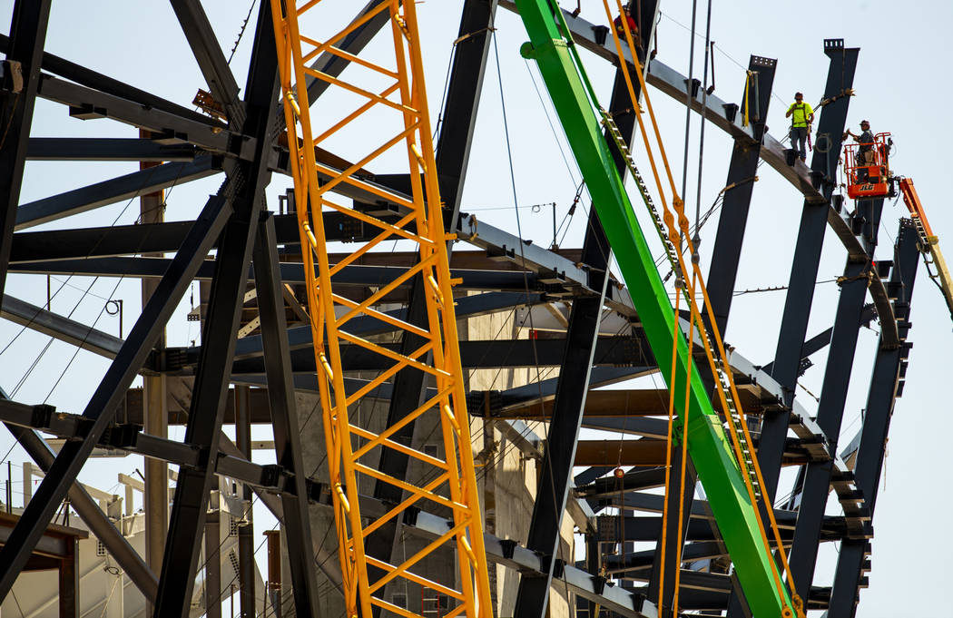 Steelworkers ready for the newest truss to be lifted to them so they can attach it at the top o ...