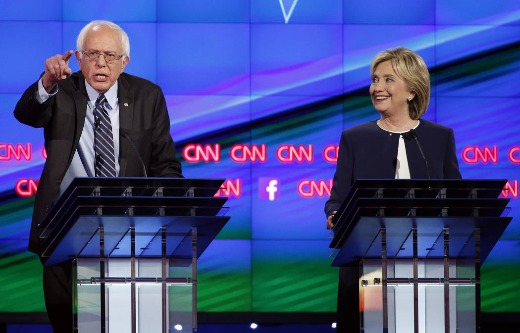 In this Tuesday, Oct. 13, 2015, file photo, Sen. Bernie Sanders, of Vermont, left, speaks as Hi ...