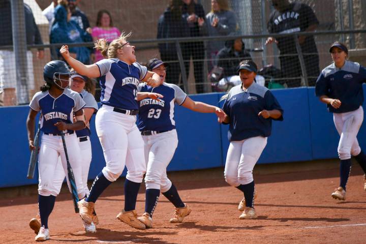 Shadow Ridge players celebrate a home run by Caitlin Covington, not pictured, during the second ...