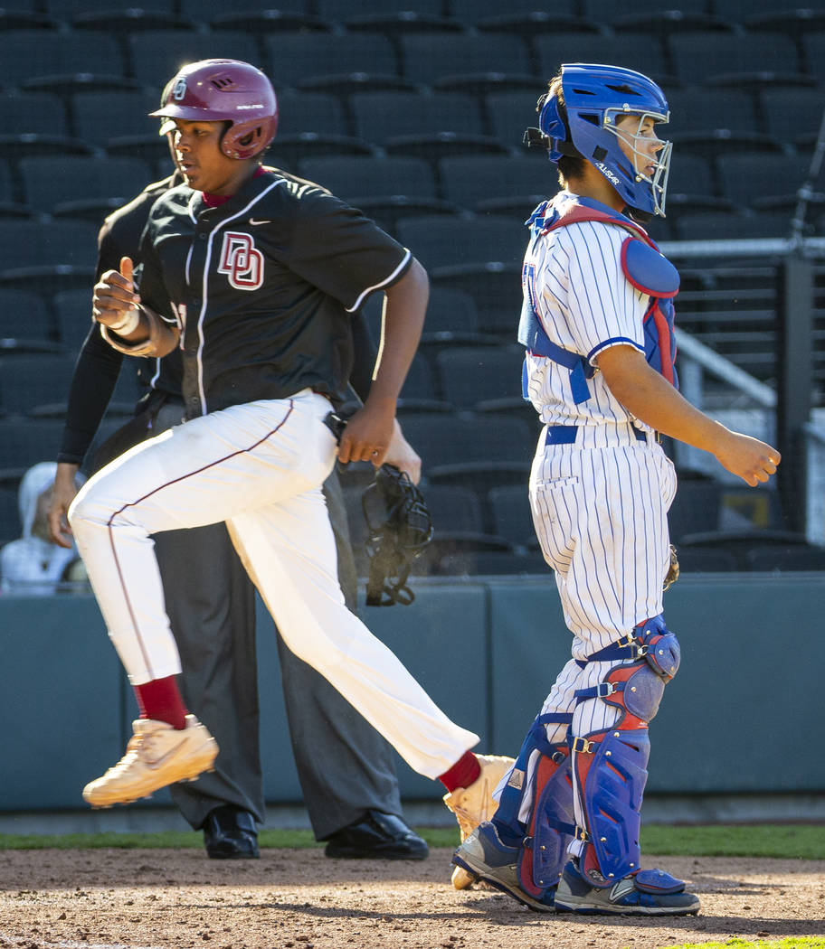 Desert Oasis' Jacob Walsh (21) scores as Reno catcher Lane Oliphant (28) waits for the throw du ...