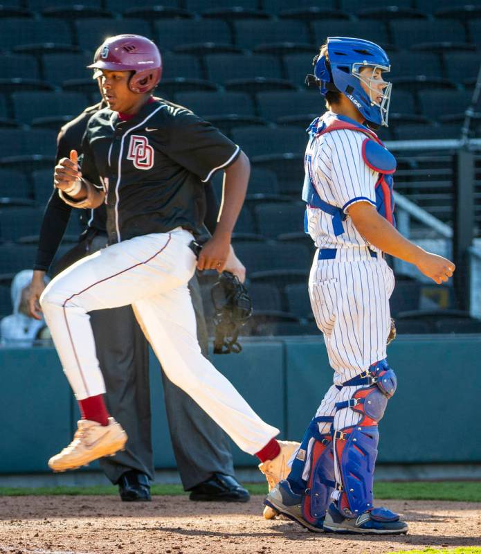 Desert Oasis' Jacob Walsh (21) scores as Reno catcher Lane Oliphant (28) waits for the throw du ...