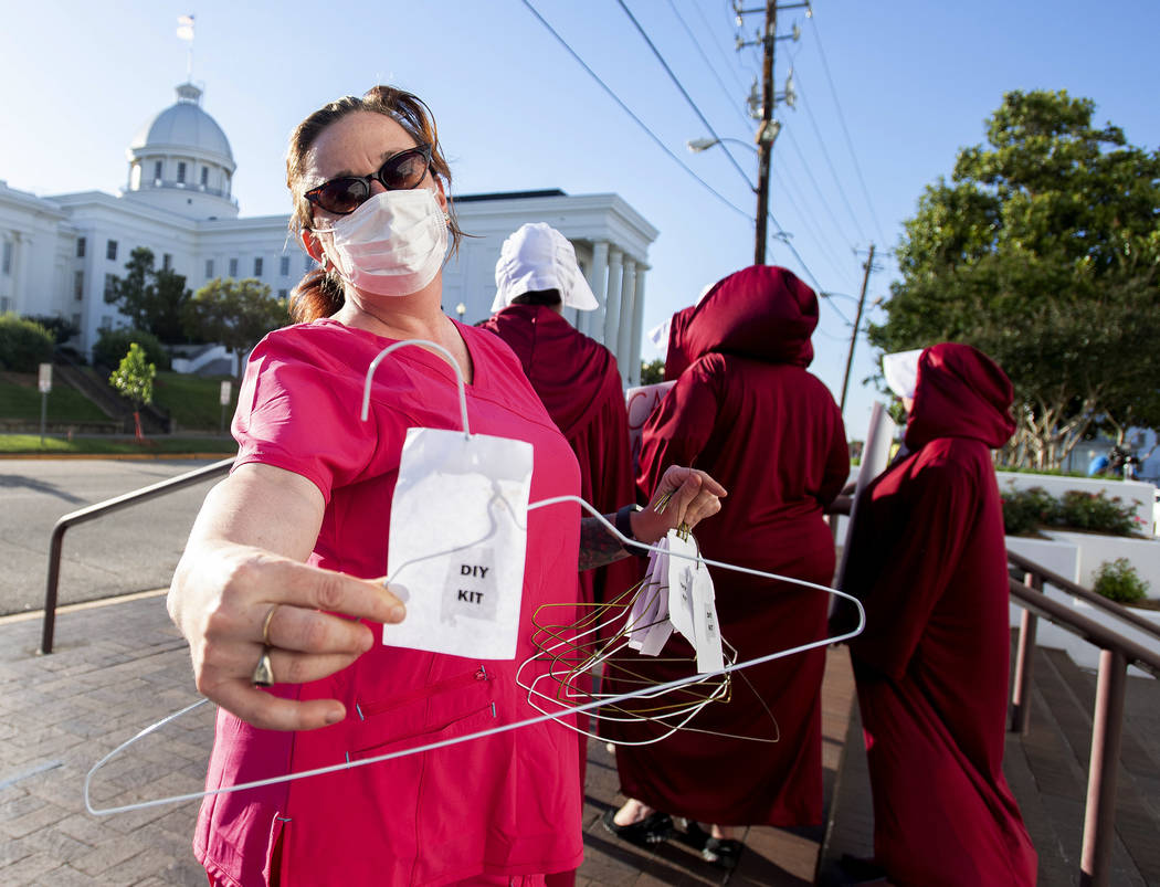 Laura Stiller hands out coat hangers as she talks about illegal abortions during a rally agains ...