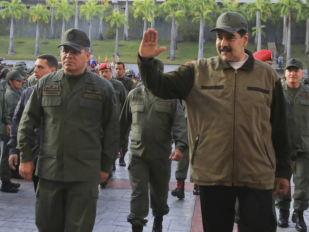 In this photo released by Miraflores Press Office, Venezuela's President Nicolas Maduro, right, ...