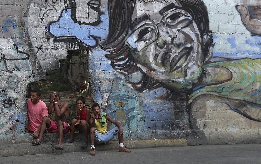 A group of young people rest in a hole in the wall at the Agua Salud neighborhood of Caracas, V ...