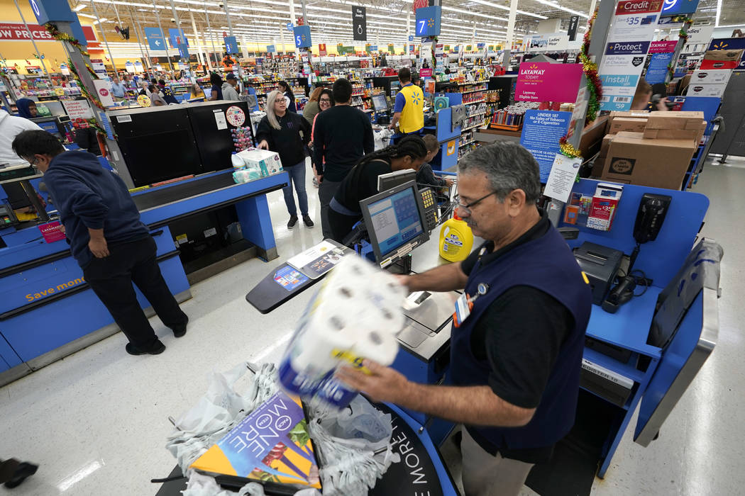 FILE - In this Nov. 9, 2018, file photo Walmart associate Javaid Vohar, right, checks out custo ...