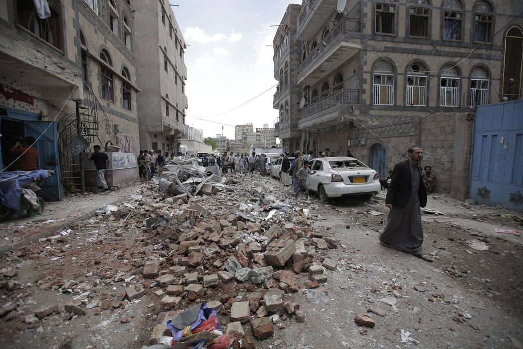 People inspect the site of an airstrike by Saudi-led coalition forces, in Sanaa, Yemen, Thursda ...