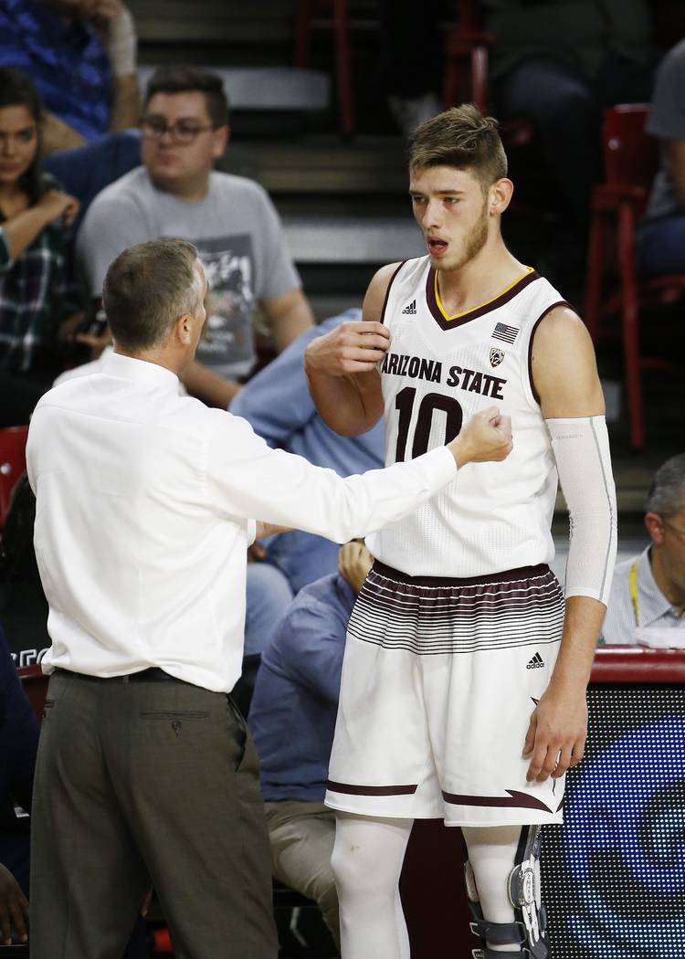 Arizona State head coach Bobby Hurley, left, talks with forward Vitaliy Shibel (10) during the ...