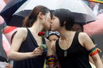 Same-sex marriage supporters kiss outside the Legislative Yuan Friday, May 17, 2019, in Taipei, ...