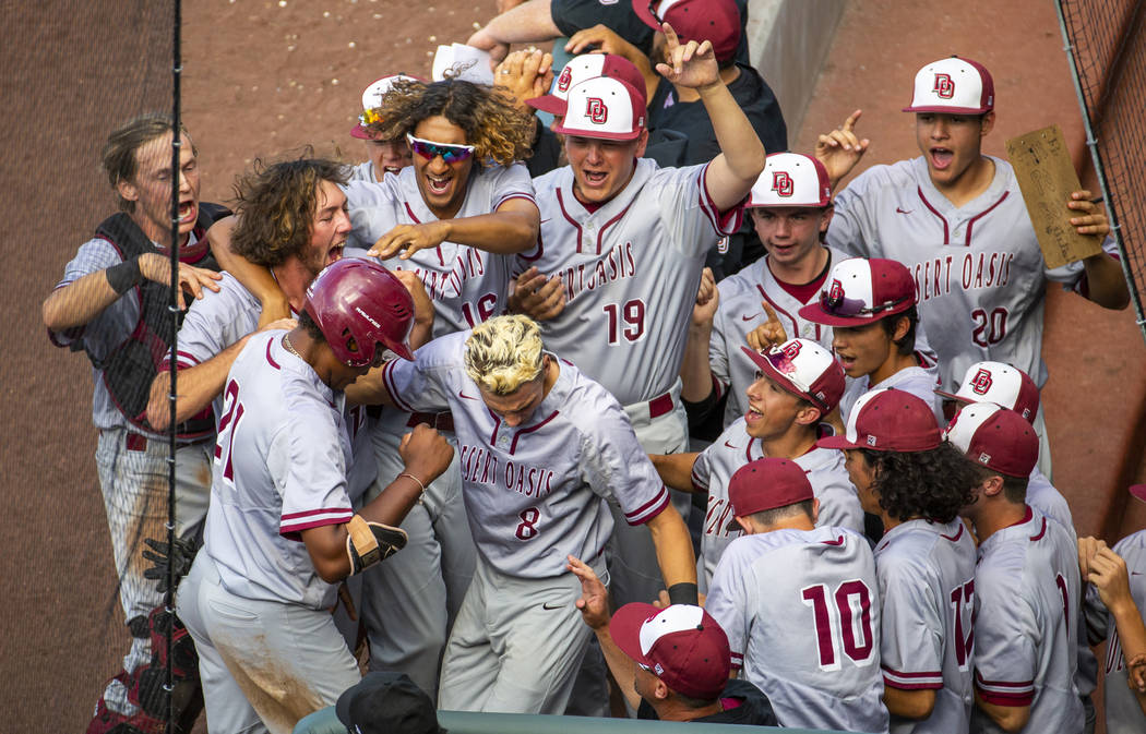 Desert Oasis teammates celebrate a run by Jacob Walsh (21) over Reno in the second inning durin ...