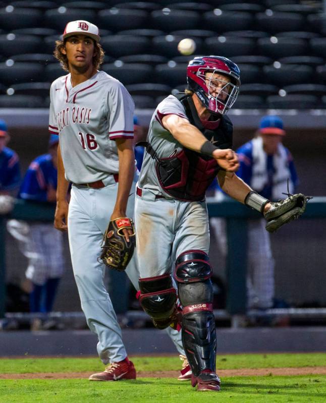 Desert Oasis pitcher DJ Jefferson Jr. (16) looks on as catcher Parker Schmidt (4) makes a throw ...