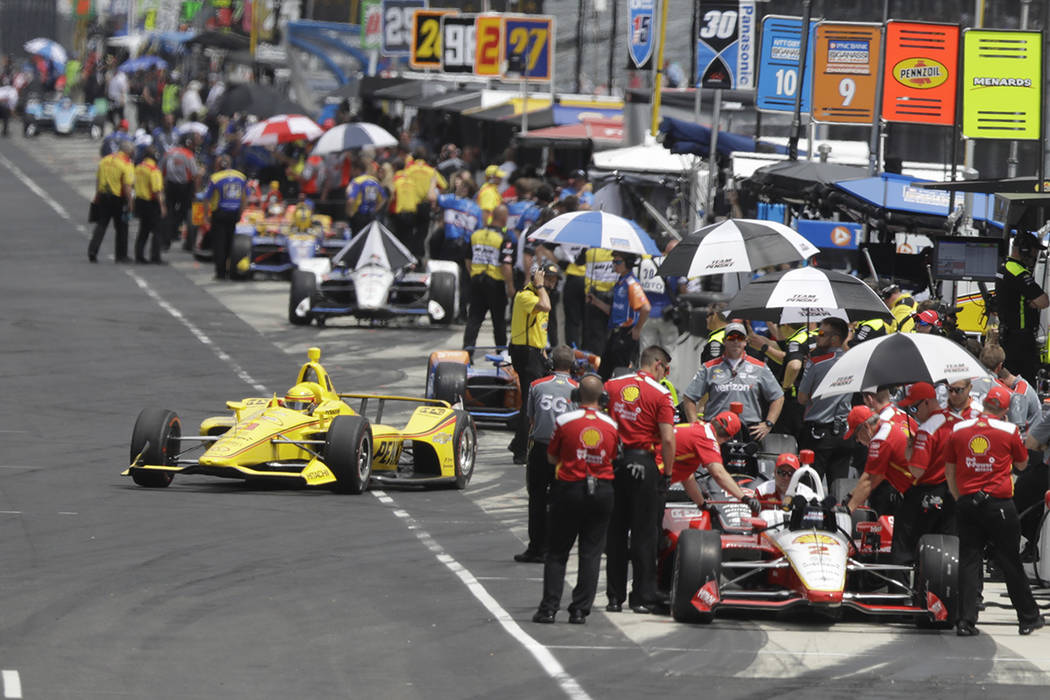 Helio Castroneves, of Brazil, pulls out of the pits during practice for the Indianapolis 500 In ...