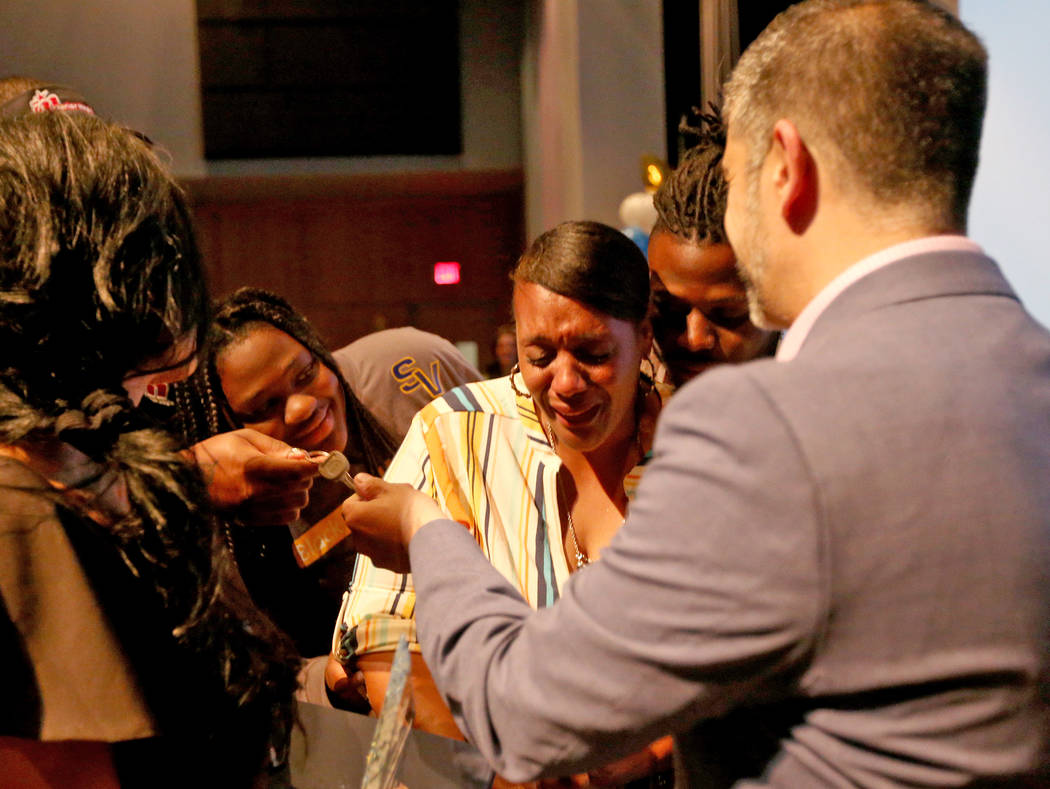 Surrounded by her kids Loren Sampey, 16, and Bryan LaGrange, Tyria Smith, center, reacts after ...