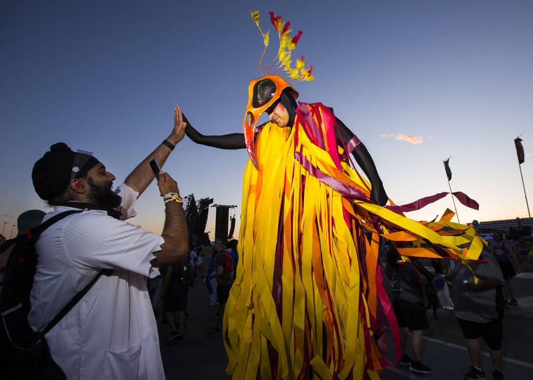 Hardeep Singh, of San Francisco, left, high-fives a costumed performer during the first day of ...