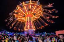 People fly high above the concert grounds on a giant swing during day two of Electric Daisy Car ...