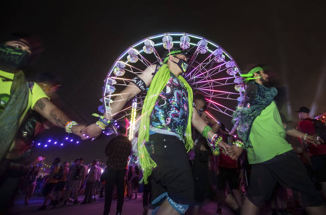 Concert goers pass by a giant ferris wheel during day two of Electric Daisy Carnival at Las Veg ...