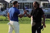 Brooks Koepka, left, shakes hands with Tiger Woods after finishing the second round of the PGA ...