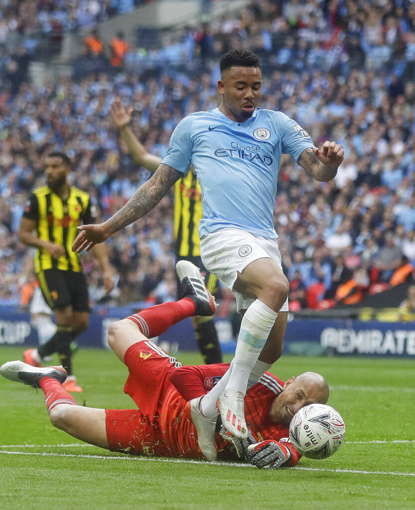 Watford's goalkeeper Heurelho Gomes tries to stop Manchester City's Gabriel Jesus during the En ...