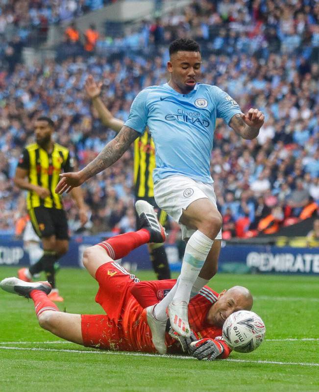 Watford's goalkeeper Heurelho Gomes tries to stop Manchester City's Gabriel Jesus during the En ...