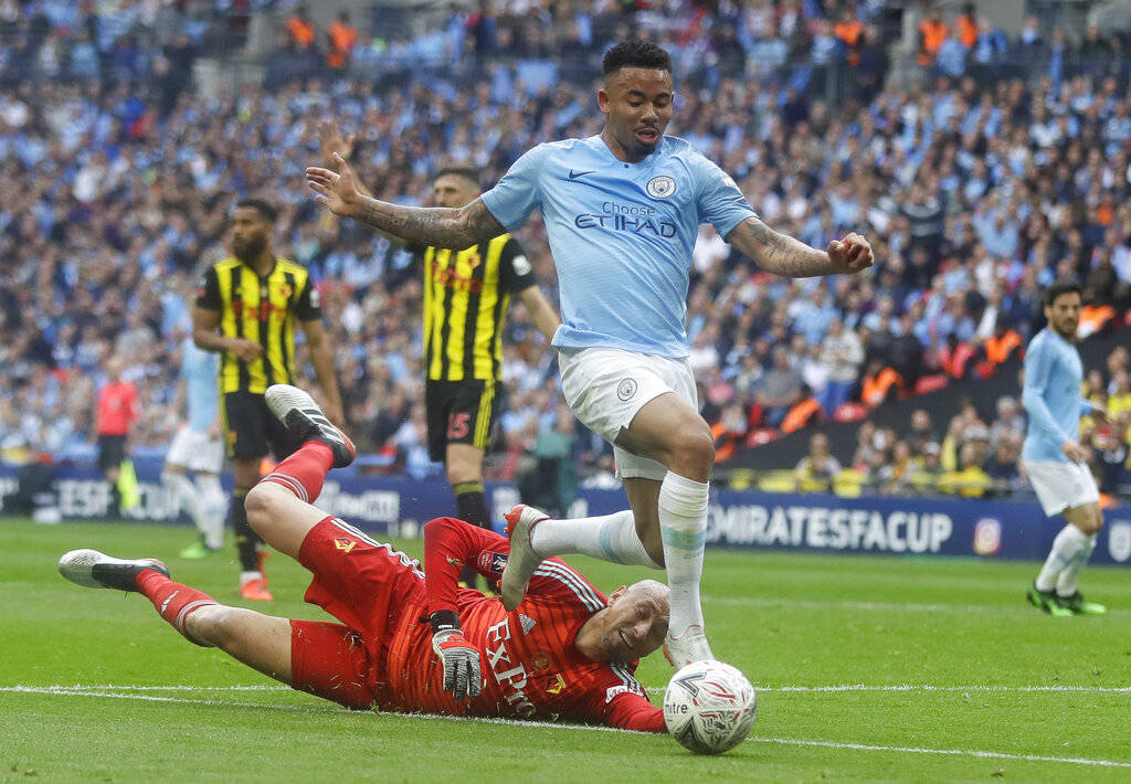 Watford's goalkeeper Heurelho Gomes tries to stop Manchester City's Gabriel Jesus during the En ...