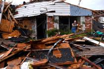 Wesley Mantooth lifts a wooden chair out a window of the home of his father, Robert, in Abilene ...